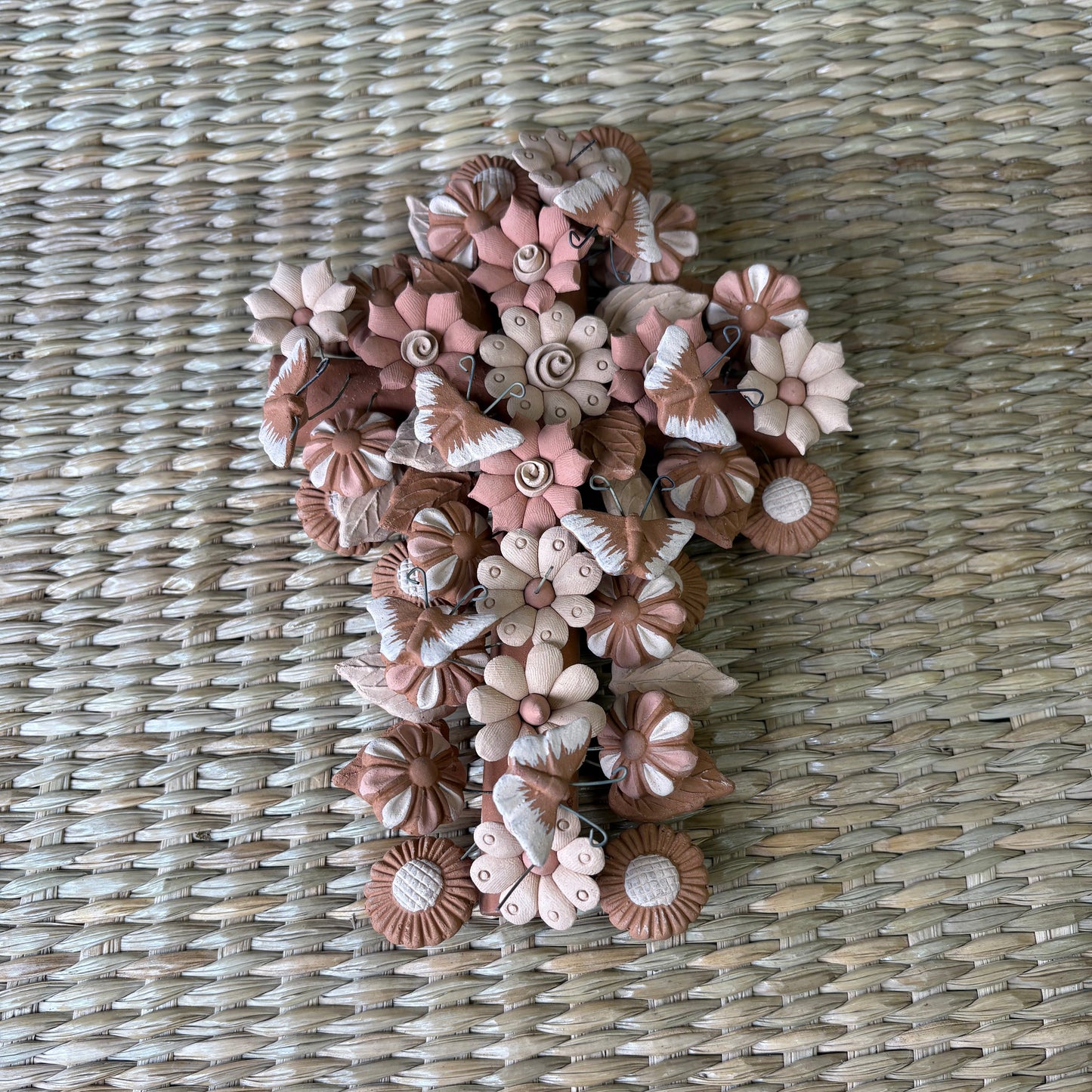 Decorative cross shape, made from artisanal seashell flowers, butterflies. It is designed as a delicate handcrafted piece of art or home decor