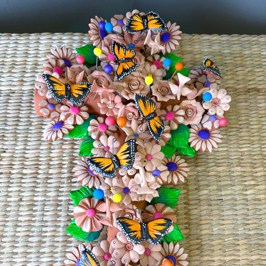 Mexican handcrafted clay wall cross, specifically as a Metepec pottery. Style sculpture adorned with Monarch butterflies and flowers.
