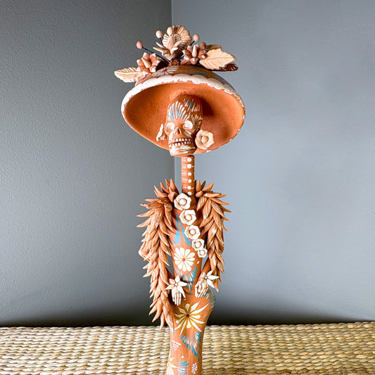 Catrine figurine. collectible item for the Day of the death, It is constructed from clay and features intricate, handcrafted detailss such as a large hat, sloral decorations, and hand-painted skeleton face