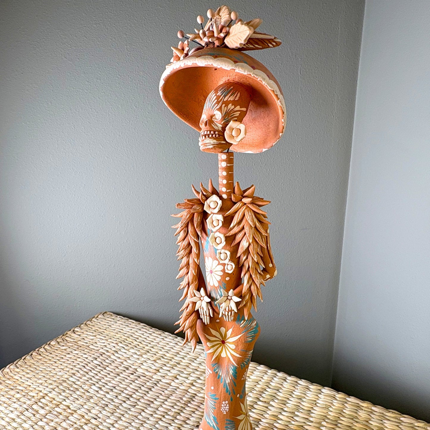 Catrine figurine. collectible item for the Day of the death, It is constructed from clay and features intricate, handcrafted detailss such as a large hat, sloral decorations, and hand-painted skeleton face