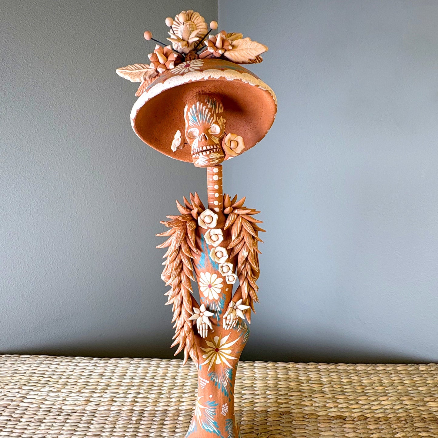 Catrine figurine. collectible item for the Day of the death, It is constructed from clay and features intricate, handcrafted detailss such as a large hat, sloral decorations, and hand-painted skeleton face