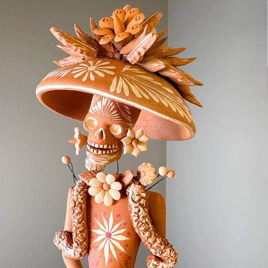 Catrine figurine. collectible item for the Day of the death, It is constructed from clay and features intricate, handcrafted detailss such as a large hat, sloral decorations, and hand-painted skeleton face