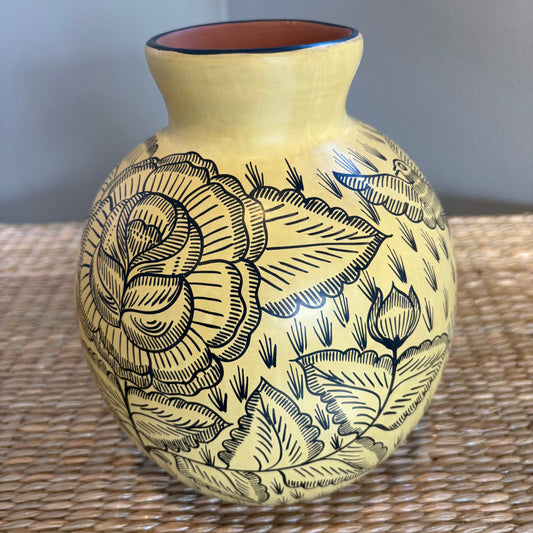 Handcrafted clay vase fom Michoacan-Mexico, featuring intricate, hand-painted black floral motifs on a cream yellow blackground.